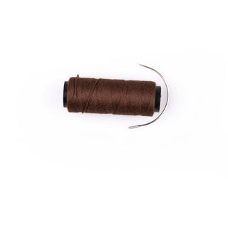 Spool of brown thread on a white background