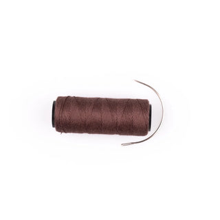 Spool of brown thread on a white background