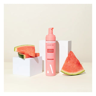Pink bottle with watermelon slices on a beige background