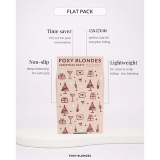 A flat pack of Foxy Blondes Christmas Party hair foil on a white background. The packaging is beige with dark red illustrations of Christmas trees, gifts, and envelopes, surrounded by callout text highlighting its features: 'Time saver', '15x27cm', 'Non-slip', and 'Lightweight'.