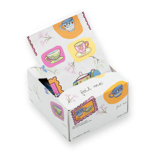 Box of tea bags with colorful teacup designs on a white background