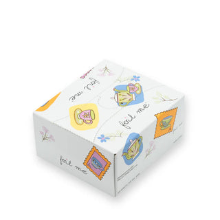 White cube-shaped box with colorful tea cup illustrations on a white background