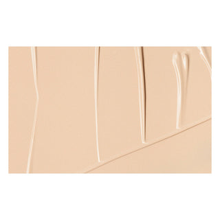Close-up of beige makeup product with a clear lid
