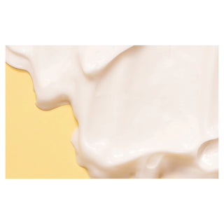 Close-up of a flowing white cream on a yellow background