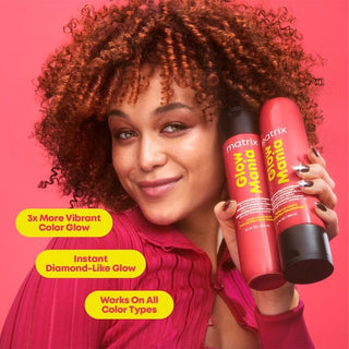 Woman holding Matrix hair care products against a pink background