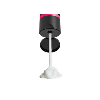 Black and pink cylindrical device with a white string and foam ball on a white background