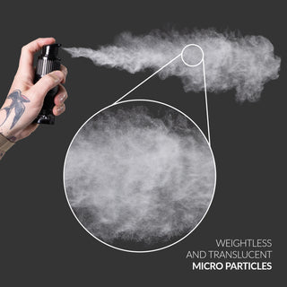 Hand holding a spray device with mist and close-up of particles on a dark background