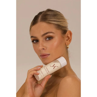 Woman holding a skincare product with a neutral background